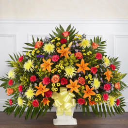 Large standing floral spray with orange, yellow, red, and purple flowers