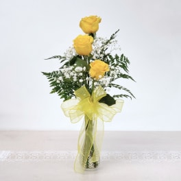 Yellow roses in a clear vase with a yellow ribbon