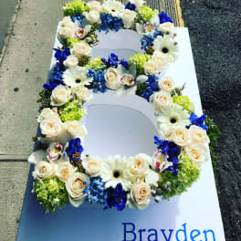 Floral number 6 with white roses, daisies, and blue flowers on a sign