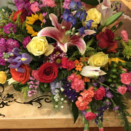 Colorful mixed flower arrangement with roses, lilies, and sunflowers on a table