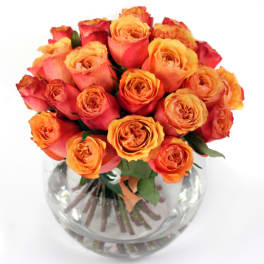 Bouquet of orange and pink roses in a clear glass vase