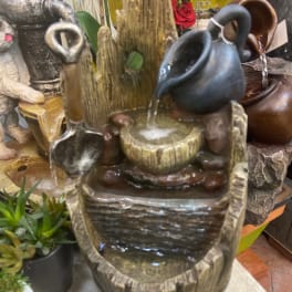 Decorative tabletop water fountain with ceramic pitchers and bowls