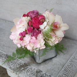 Pink and white bouquet with roses and orchids in a silver vase