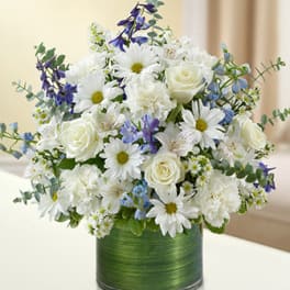 White and blue mixed bouquet in a green vase