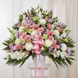 Large pink and white floral spray with a pink ribbon on a pedestal
