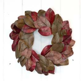 Leaf wreath in red, burgundy, and brown tones on a white door