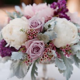Lavender roses and white peonies in a low bouquet with silver foliage