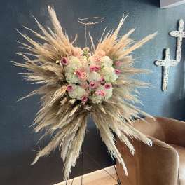 Large floral spray with pink and white blooms and pampas grass on a stand