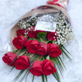 Bouquet of red roses with white baby's breath in brown paper