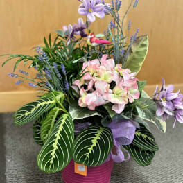 Pink and lavender floral arrangement in a magenta pot