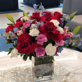 Red roses and pink carnations in a clear glass vase
