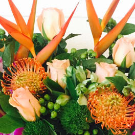Tropical bouquet with orange heliconia, peach roses, and orange pincushion blooms