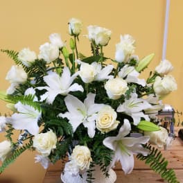 White lilies and roses arranged in a white vase