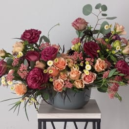 Mixed pink and peach roses in a gray bowl vase