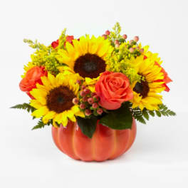 Sunflowers and coral roses arranged in a pumpkin-shaped vase