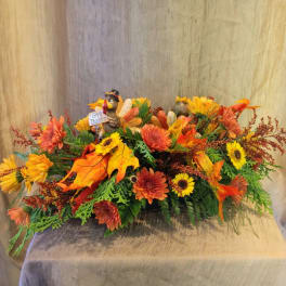 Autumn floral centerpiece with sunflowers, mums, and a small turkey figurine