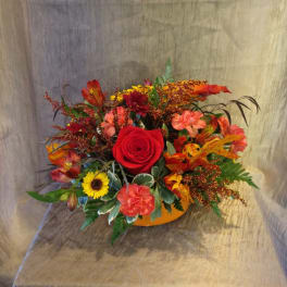 Mixed bouquet with a red rose in an orange container