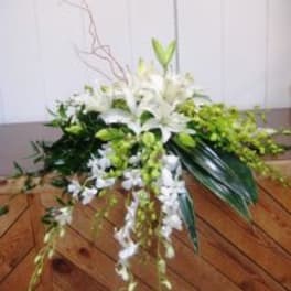 White lily arrangement with cascading orchids and green accents