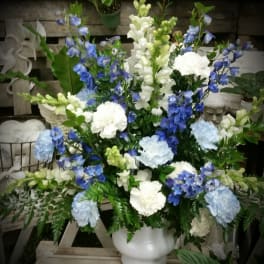 Blue and white floral arrangement in a white vase