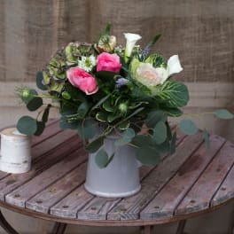 Pink and white floral arrangement in a gray vase