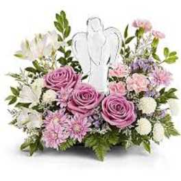 Pink and white floral arrangement with a white angel figure in the center