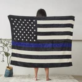 Person holding a black-and-white American flag blanket with a blue stripe