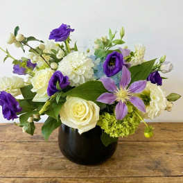 Purple and white mixed bouquet in a dark vase