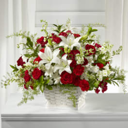 Red roses and white lilies arranged in a white basket