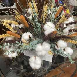 Arrangement of cotton bolls, wheat, and dried grasses in a container