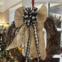 Rustic grapevine wreath with a burlap bow and black-and-white ribbon
