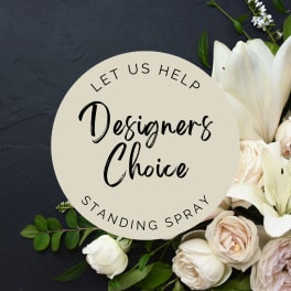 White lilies and pale roses around a circular standing spray sign