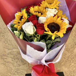 Bouquet of yellow sunflowers and red and white roses wrapped in red paper