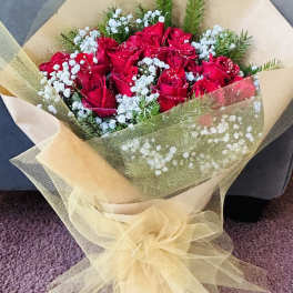 Bouquet of red roses with white baby's breath wrapped in beige tulle