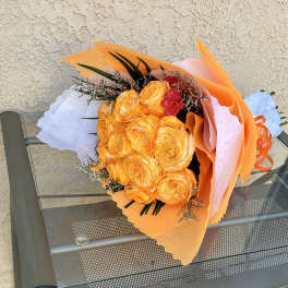 Bouquet of orange and yellow roses wrapped in pastel paper