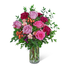 Pink roses and carnations in a clear glass vase
