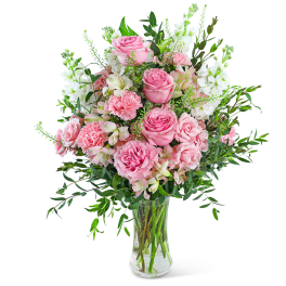 Pink roses and carnations in a clear glass vase