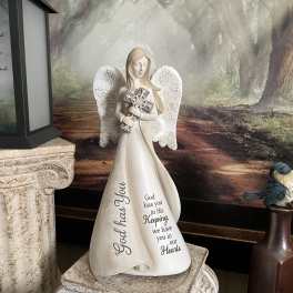 Angel figurine holding a cross with memorial text on the robe