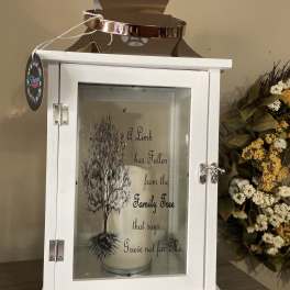 White memorial lantern with a candle and floral accents