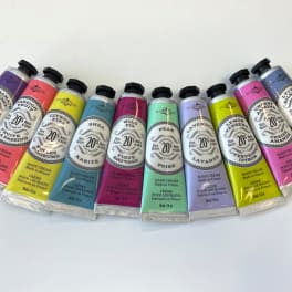 A row of colorful hand cream tubes arranged on a white surface