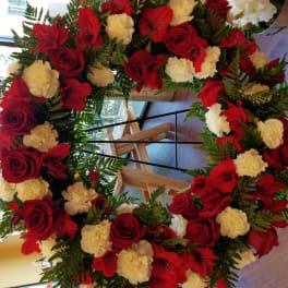 Large red and white floral wreath on a stand