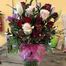 Mixed bouquet of red and pink roses with lilies in a glass vase