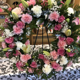 Pink and white floral wreath on a black easel