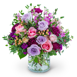 Bouquet of pink and lavender roses in a clear glass vase
