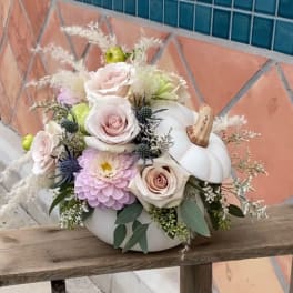 Pastel floral arrangement in a white pumpkin container