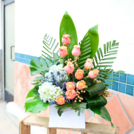 Tropical bouquet with pink roses and blue hydrangeas in a white box