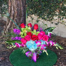 Bright mixed bouquet with roses, orchids, and hydrangea in a vase