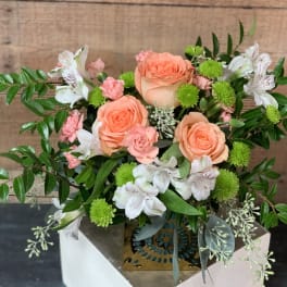Peach roses with white alstroemeria and green pompons in a decorative box