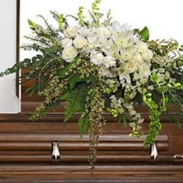 White floral spray on a wooden casket