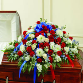 Large red, white, and blue floral spray on a casket