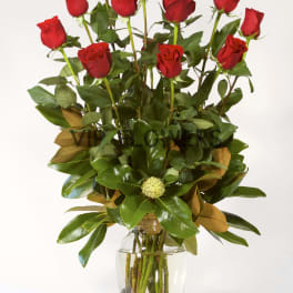 Tall bouquet of red roses in a clear glass vase